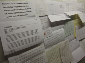 A wall covered in thank-you letters and cards from customers